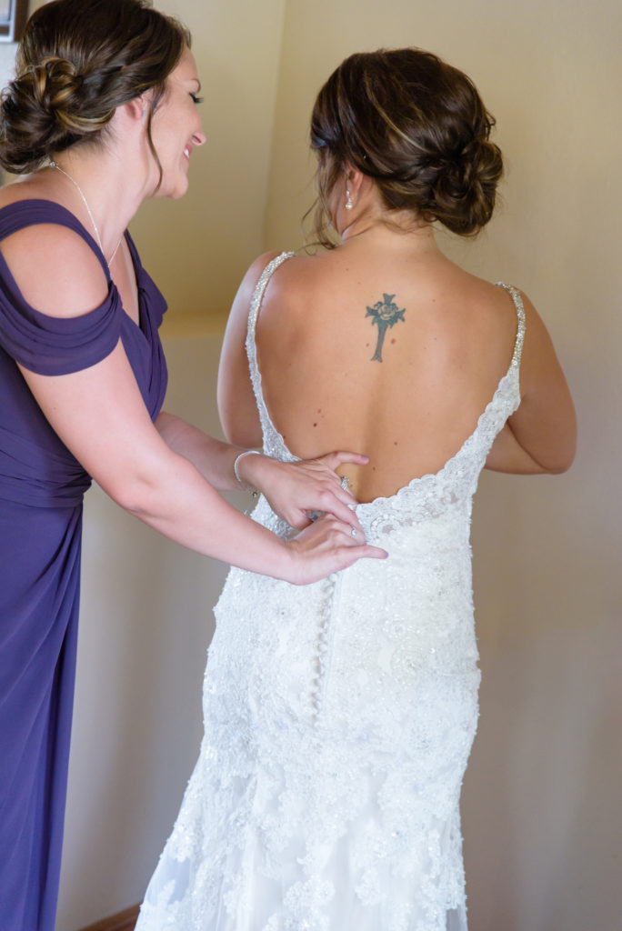 Wozniak_Wedding_040 Bride's Sister helps her get ready by buttoning her wedding dress